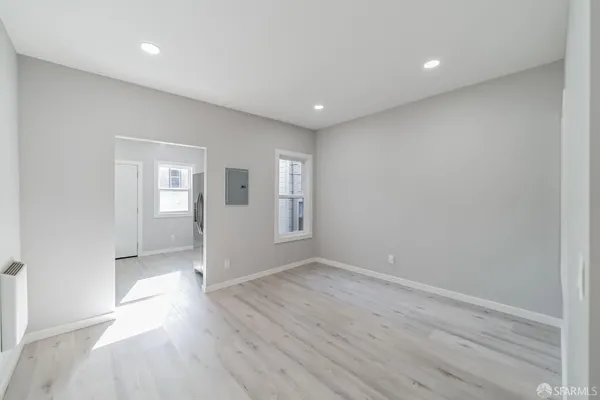 an empty room with wooden floor and windows