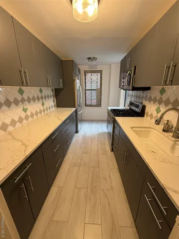 a large kitchen with kitchen island granite countertop a sink and wooden cabinets