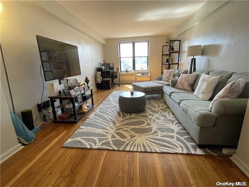 65-15 38th Avenue, Unit 5P Queens, NY 11377 - Photo 2 of 15 a living room with furniture and a flat screen tv