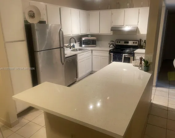 a kitchen with a refrigerator and a stove top oven