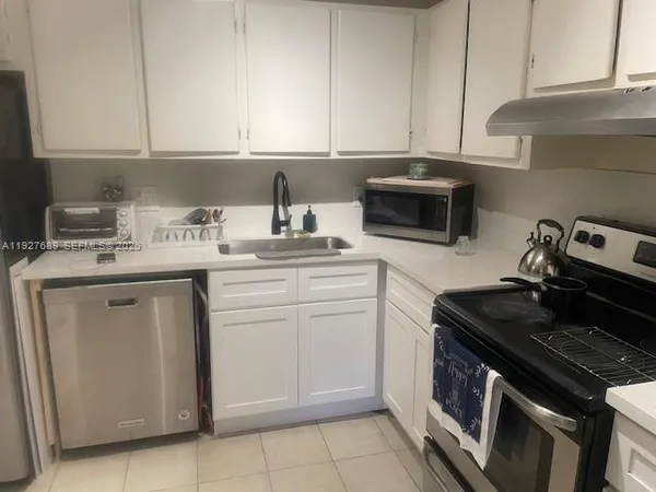 a kitchen with a sink stove and cabinets