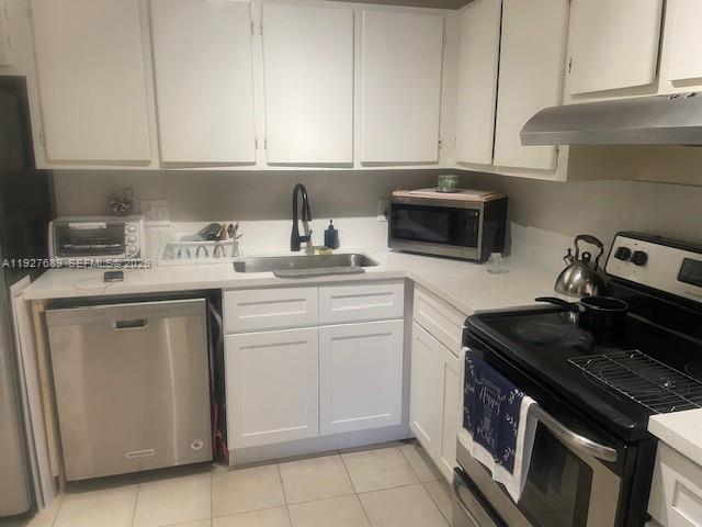 9002 Southwest 137th Street, Unit G27 Miami, FL 33176 - Photo 2 of 11 a kitchen with a sink stove and cabinets