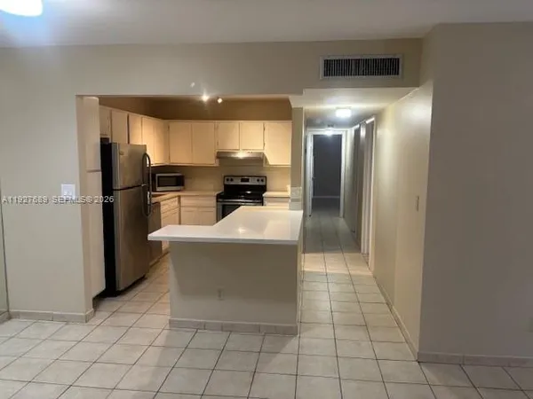 a view of a kitchen with a refrigerator and a stove
