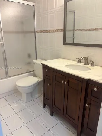 a bathroom with a granite countertop toilet a sink and a mirror