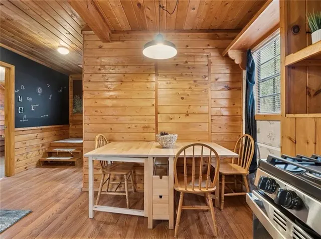 a view of a patio with table and chairs with wooden floor and wall