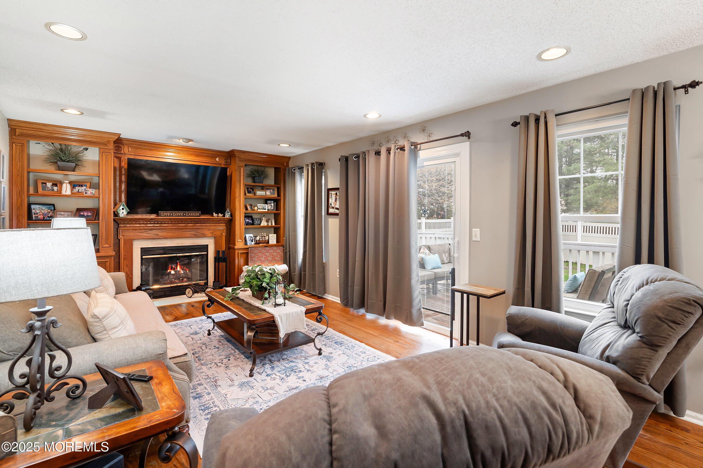 47 Crater Lake Road Howell, NJ 07731 - Photo 12 of 40 a living room with furniture a flat screen tv and a fireplace