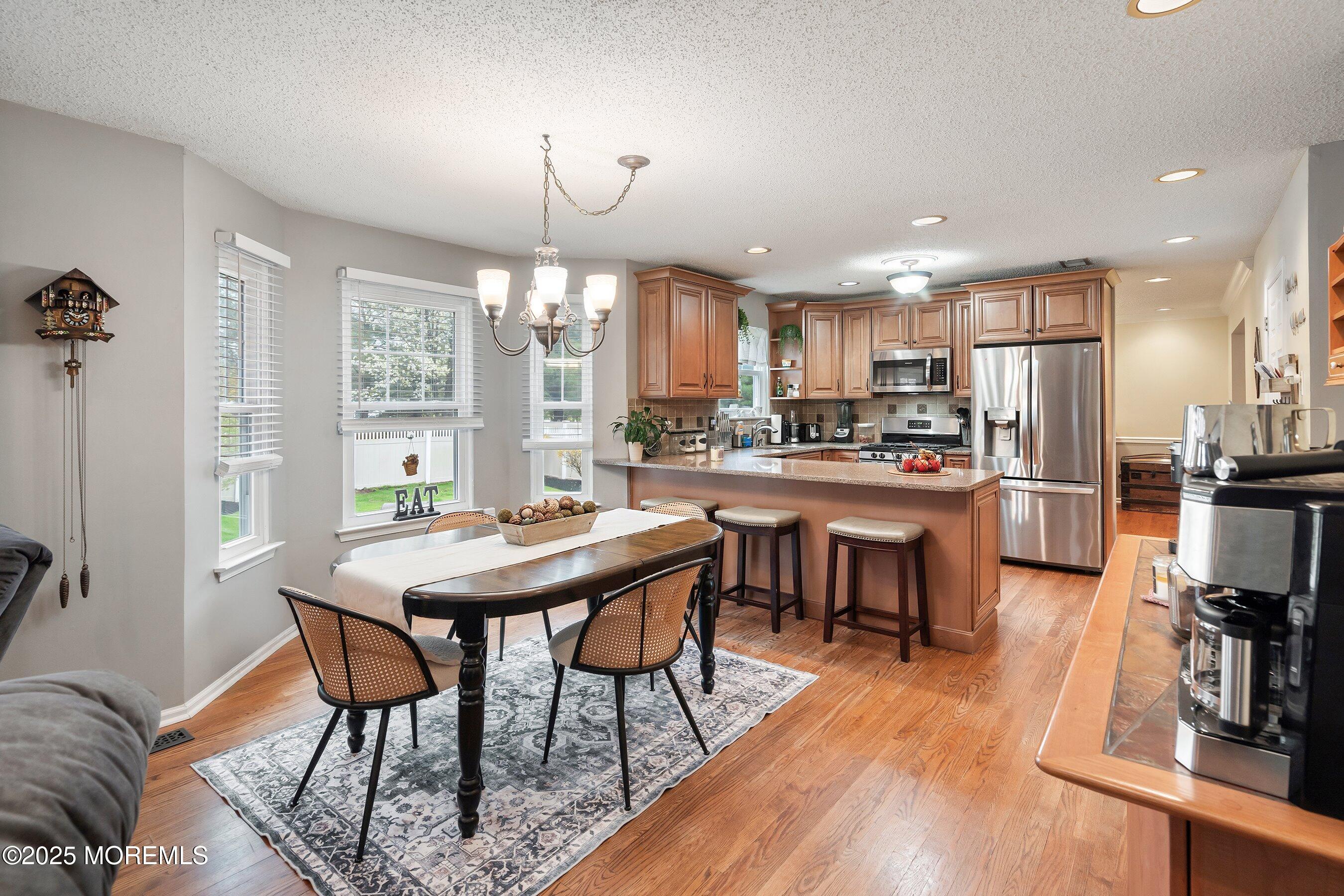 47 Crater Lake Road Howell, NJ 07731 - Photo 10 of 40 a kitchen with stainless steel appliances kitchen island granite countertop a table chairs and a refrigerator