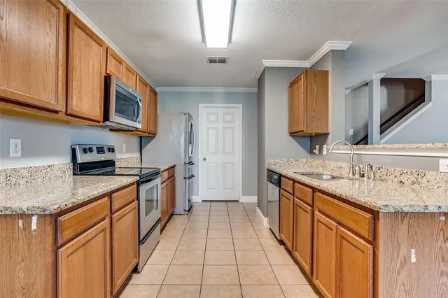 a kitchen with stainless steel appliances granite countertop a sink and a stove