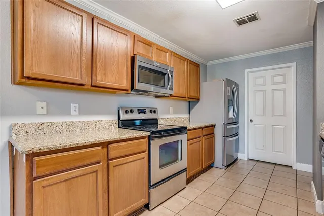 a kitchen with stainless steel appliances granite countertop a stove a sink and a microwave