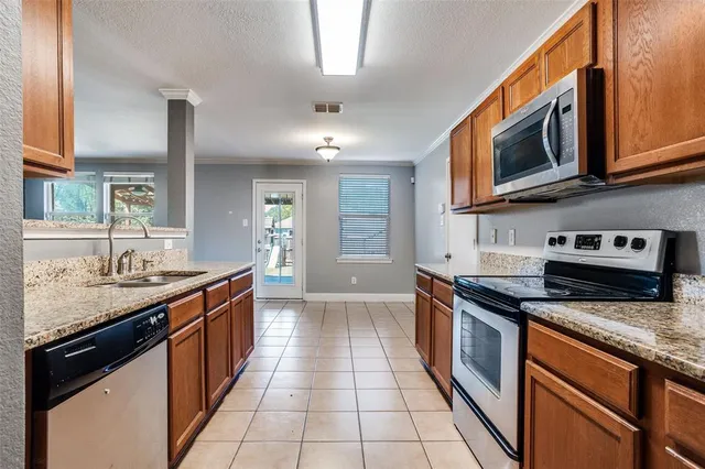 a kitchen with stainless steel appliances granite countertop a stove a sink and a microwave