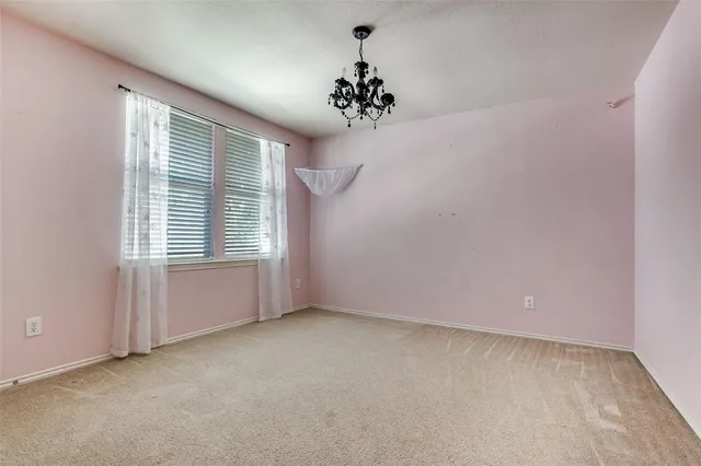 an empty room with a windows and chandelier