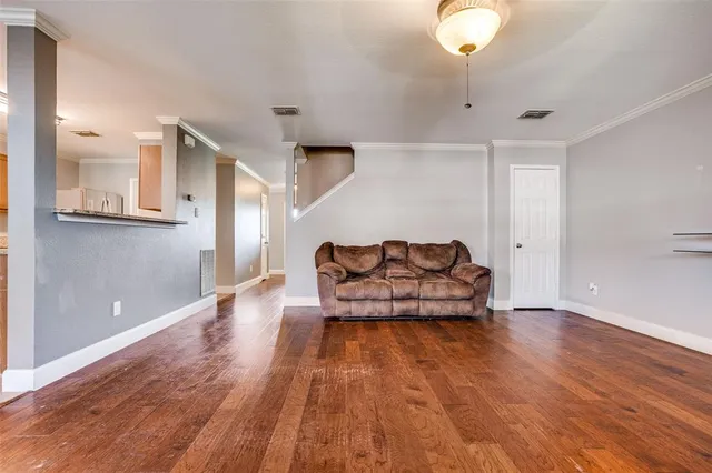 a living room with furniture and wooden floor