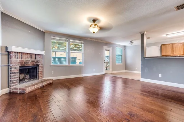 wooden floor fireplace and windows in an empty room
