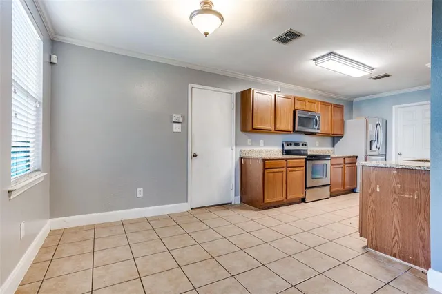 a kitchen with stainless steel appliances a stove top oven a sink a counter top space and cabinets