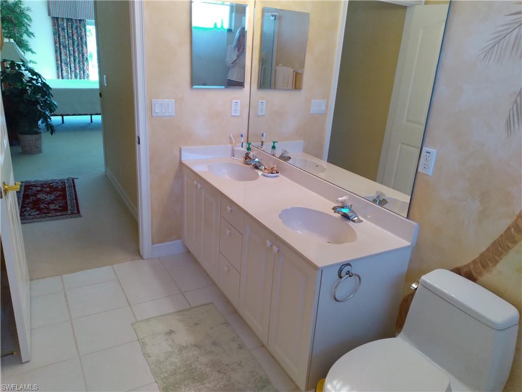 900 Diamond Circle, Unit 908 Naples, FL 34110 - Photo 13 of 22 a bathroom with a sink toilet and mirror