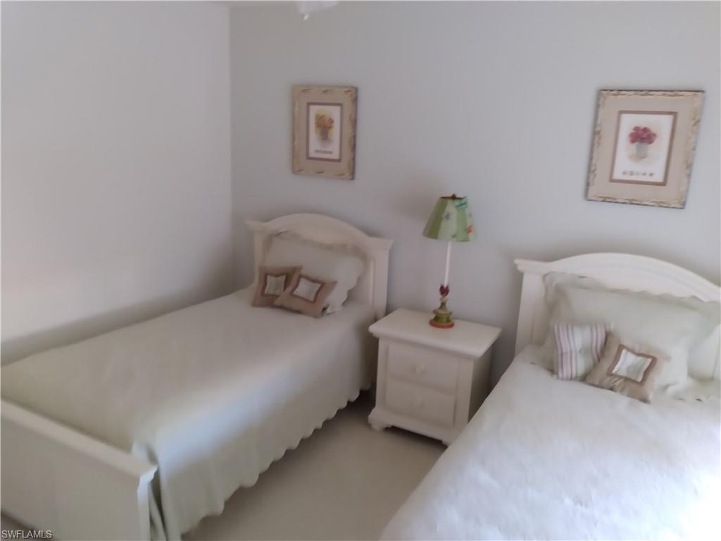 900 Diamond Circle, Unit 908 Naples, FL 34110 - Photo 20 of 22 a bedroom with a bed and a lamp