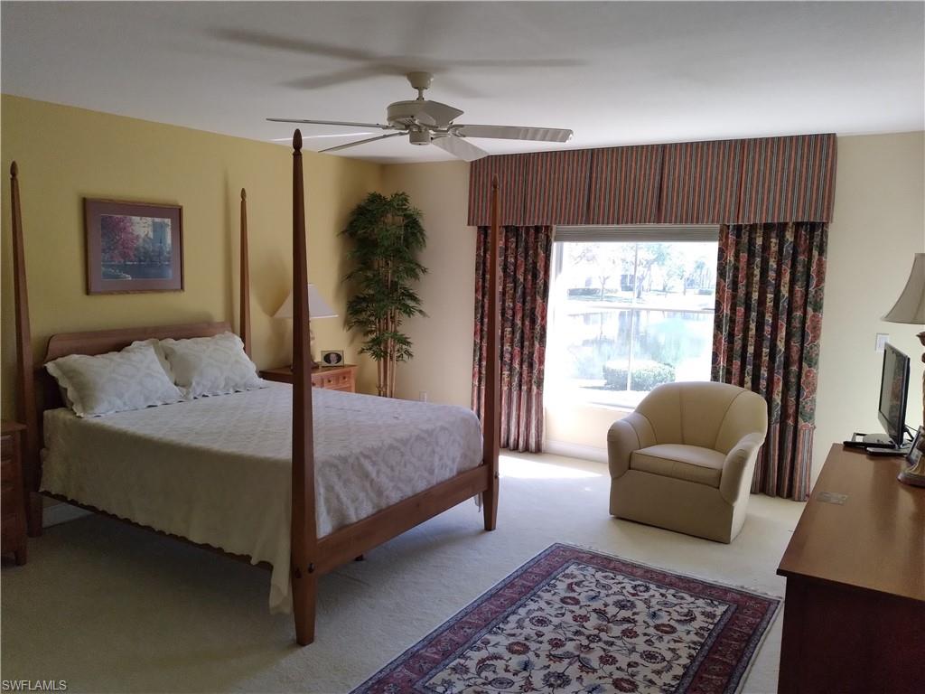 900 Diamond Circle, Unit 908 Naples, FL 34110 - Photo 4 of 22 a bedroom with a bed and a chair