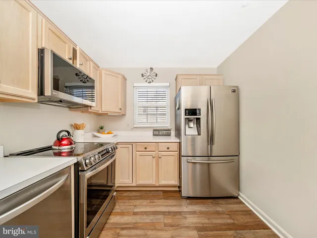 a kitchen with stainless steel appliances a refrigerator sink and microwave