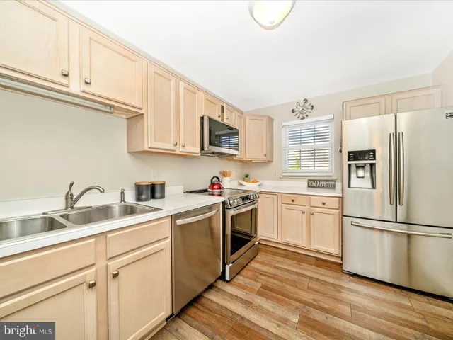 a kitchen with stainless steel appliances granite countertop a refrigerator sink and cabinets