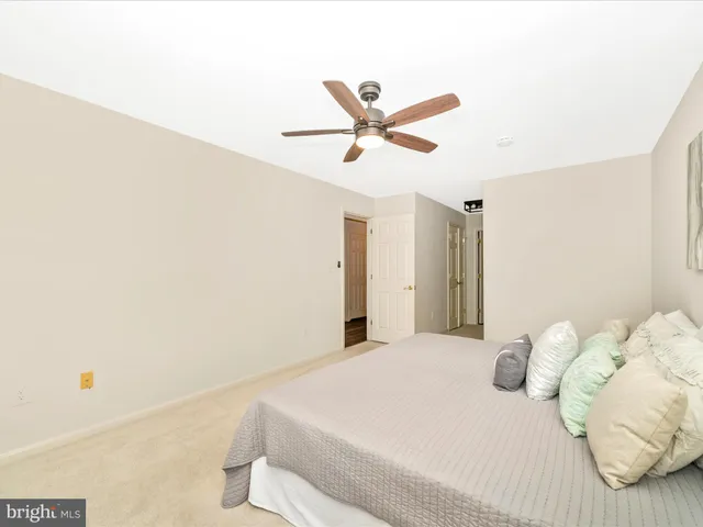 a bedroom with a bed and a ceiling fan
