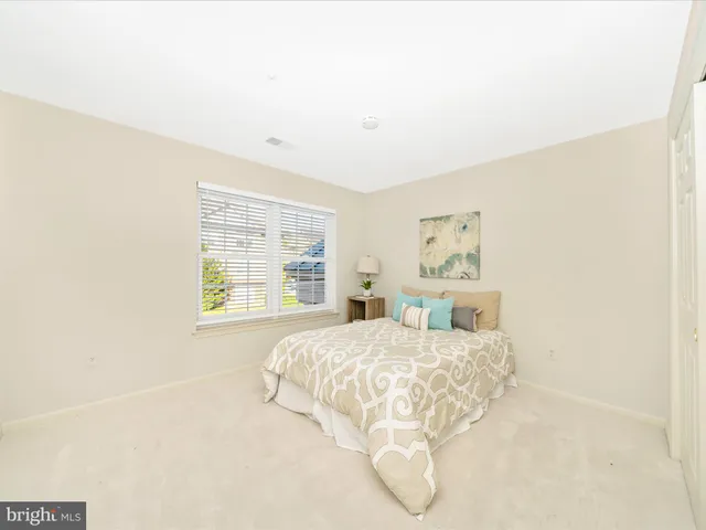 a bedroom with a bed and painting on the wall