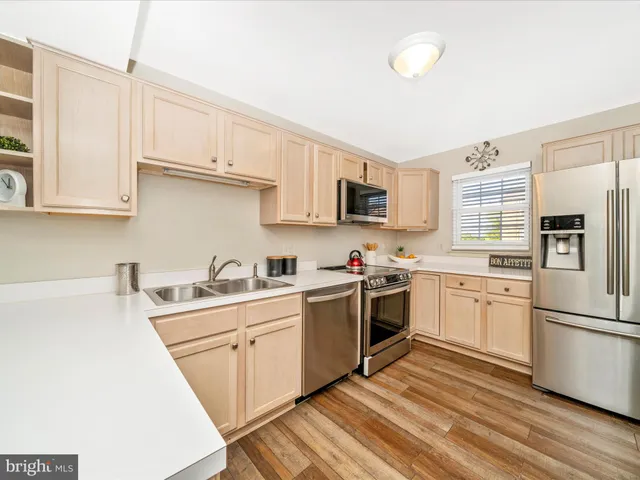 a kitchen with a sink white cabinets and stainless steel appliances