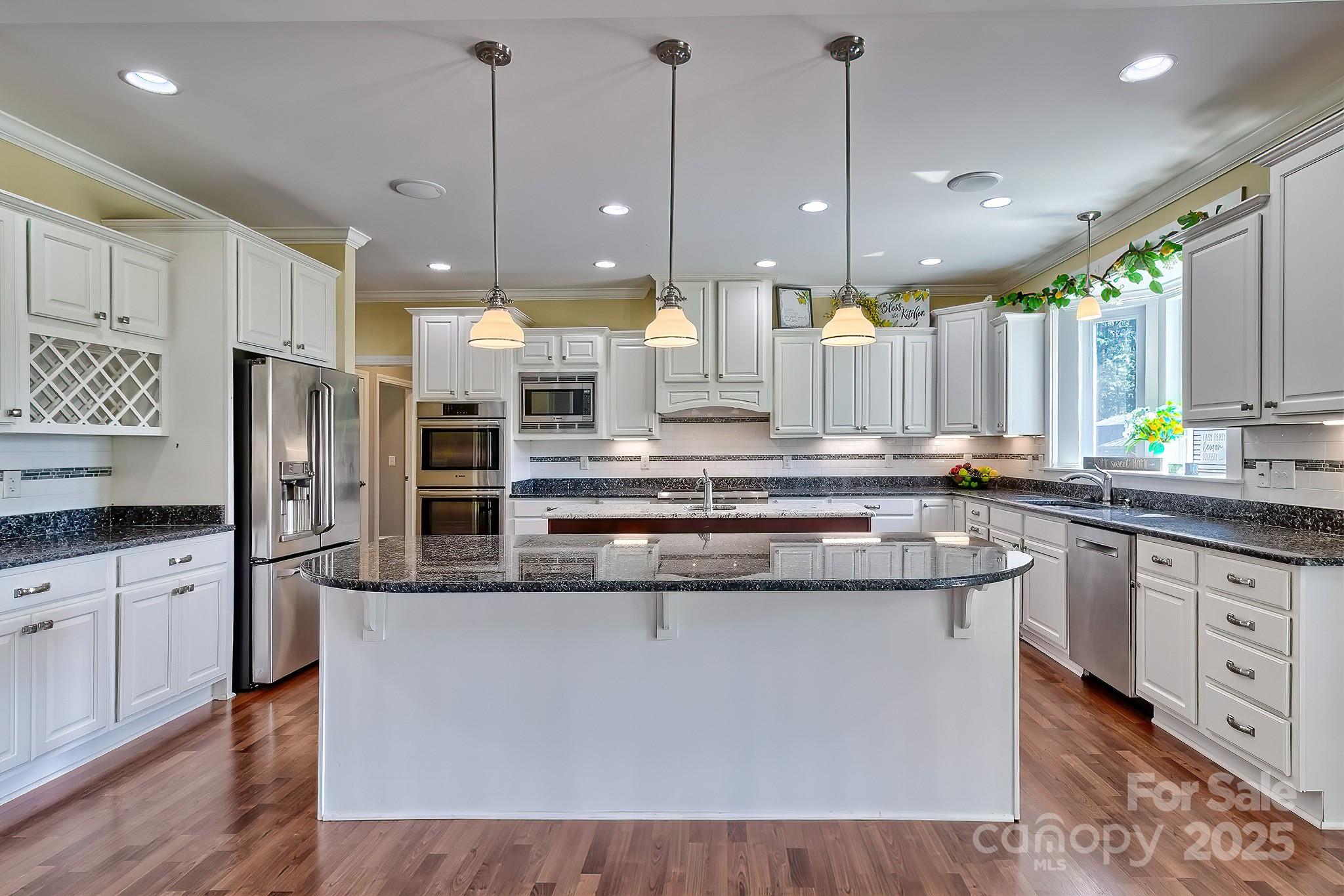 6268 Hope Road Winnsboro, SC 29180 - Photo 21 of 48 a kitchen with stainless steel appliances granite countertop wooden floors and white cabinets