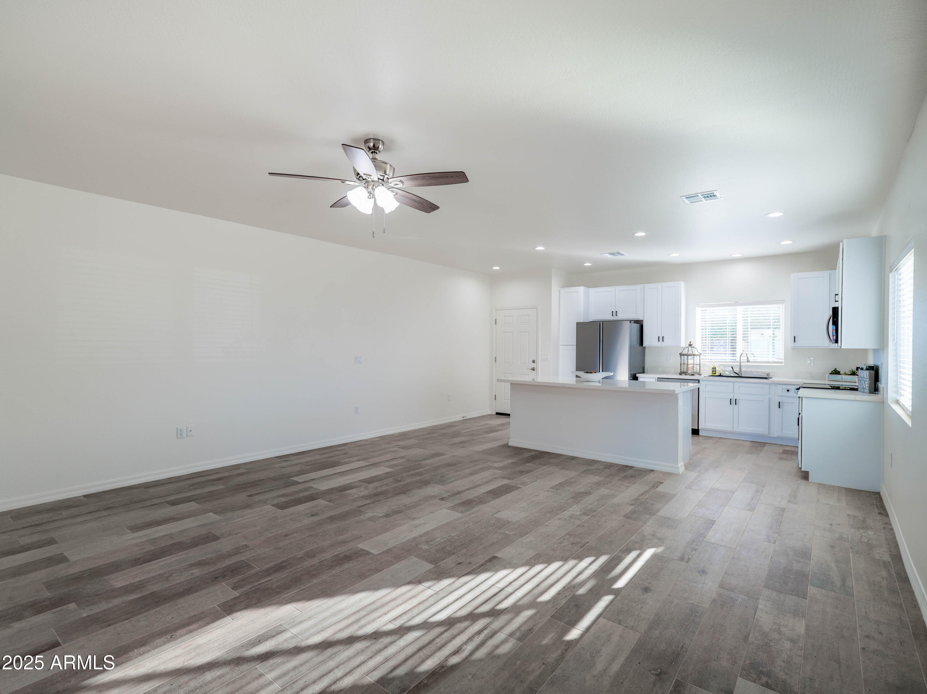 14534 South Diablo Road Arizona City, AZ 85123 - Photo 11 of 36 a view of a kitchen with wooden floor and a kitchen island