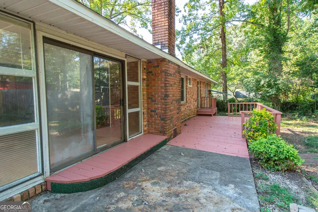 a patio with table and chairs and potted plants