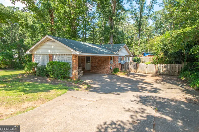 a front view of a house with a yard and trees