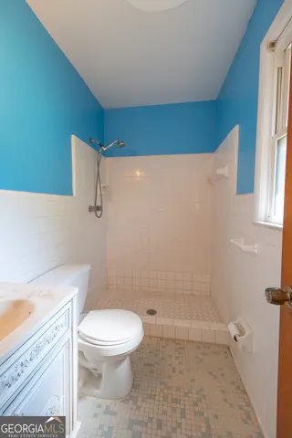a bathroom with a toilet a sink and shower