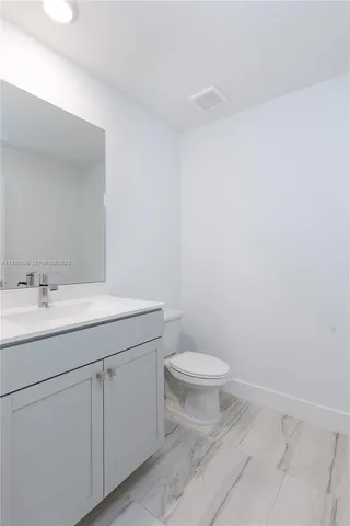 a bathroom with a granite countertop sink and toilet