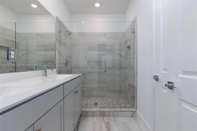 a bathroom with a shower sink and mirror
