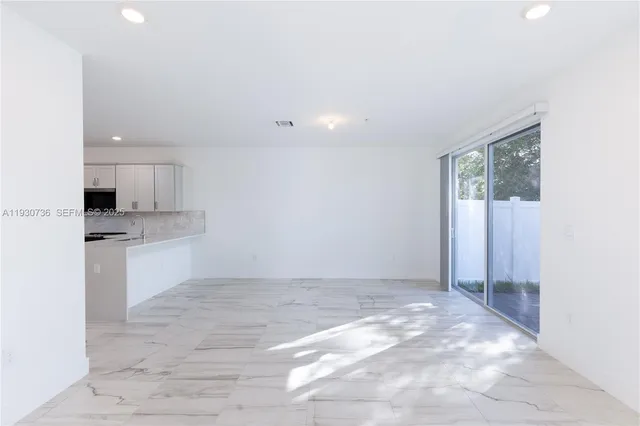 a view of kitchen with granite countertop cabinets and white appliances