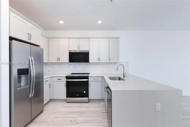 a kitchen with stainless steel appliances a refrigerator stove and microwave