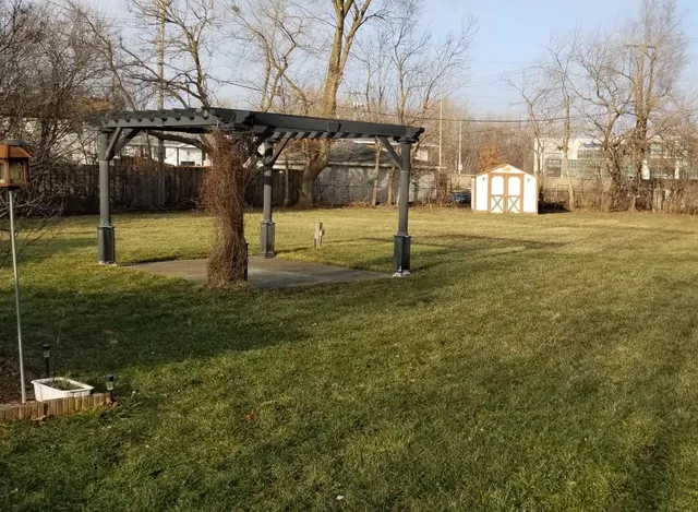 a view of a yard with yellow house