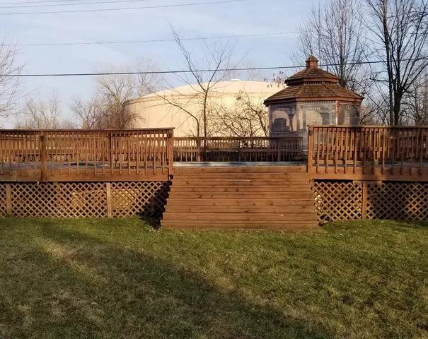 a view of a deck with a floor to ceiling window and wooden fence