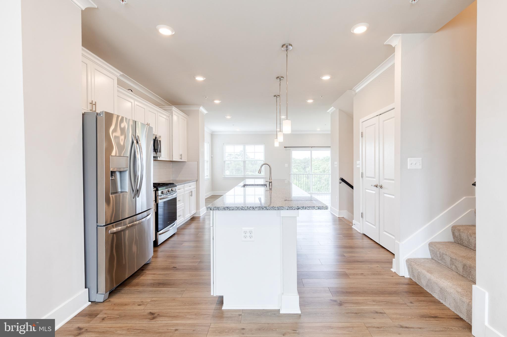 2008 Ivory Brook Road Baltimore, MD 21244 - Photo 17 of 35 a large kitchen with a center island wooden floor stainless steel appliances and windows