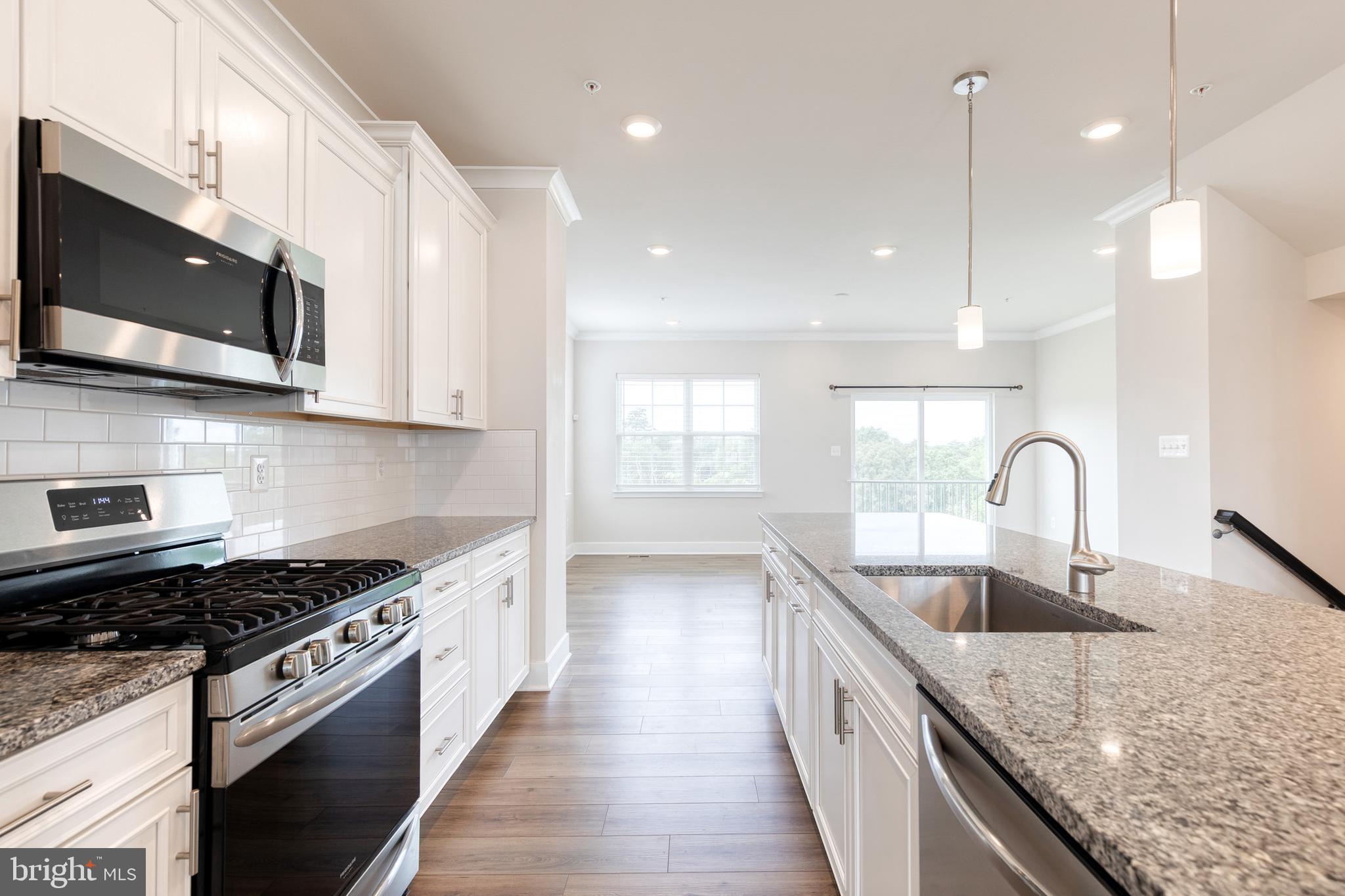 2008 Ivory Brook Road Baltimore, MD 21244 - Photo 18 of 35 a kitchen with stainless steel appliances granite countertop a sink a stove top oven a counter space and cabinets