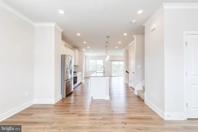 a view of a kitchen with a refrigerator and wooden floor