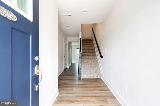 a view of a hallway with wooden floor and staircase