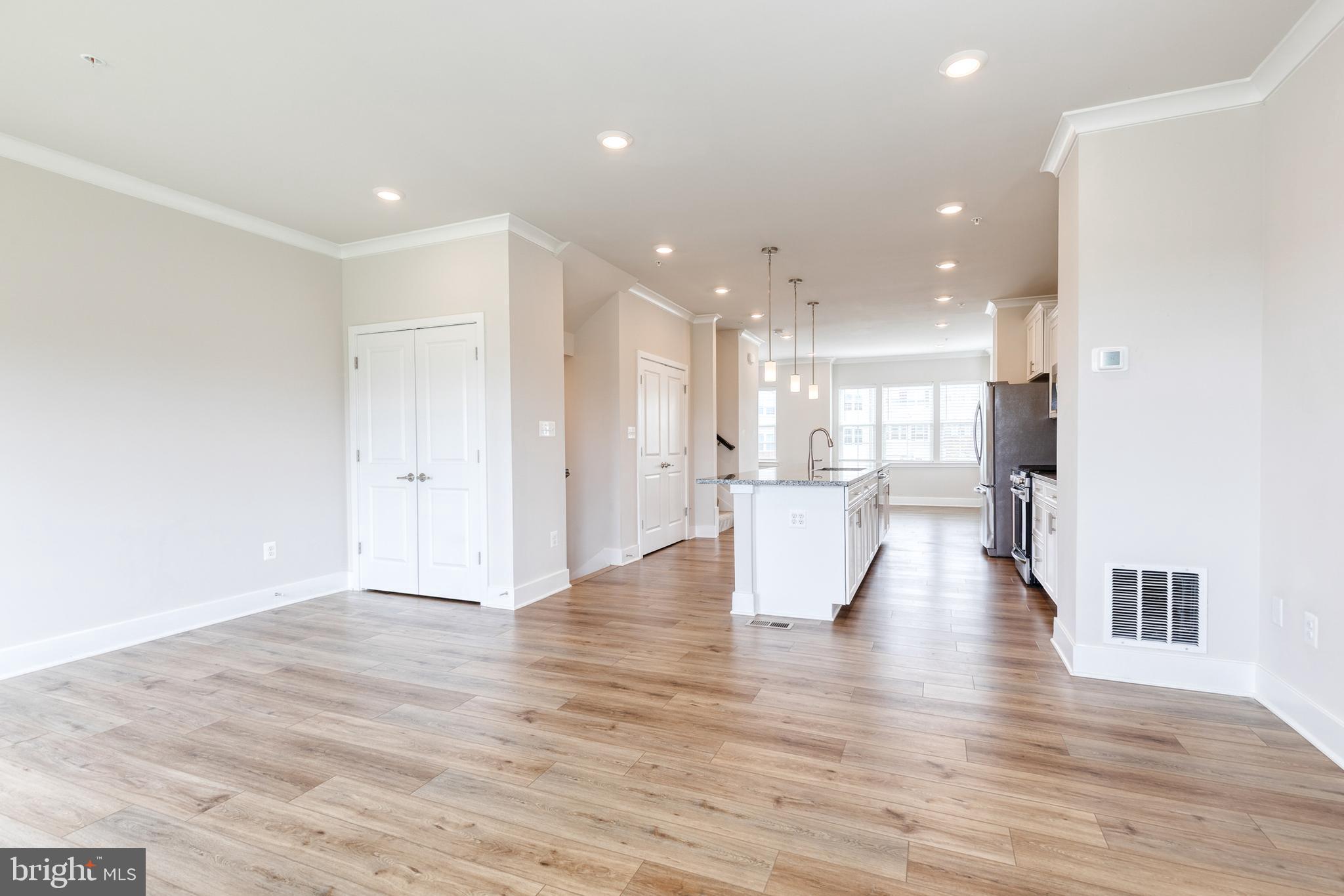 2008 Ivory Brook Road Baltimore, MD 21244 - Photo 10 of 35 a view of an empty room and kitchen with granite countertop wooden floor