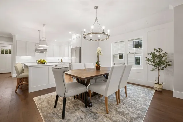 a dining room with furniture a chandelier and wooden floor