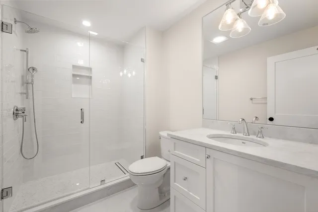 a bathroom with a sink a toilet and shower