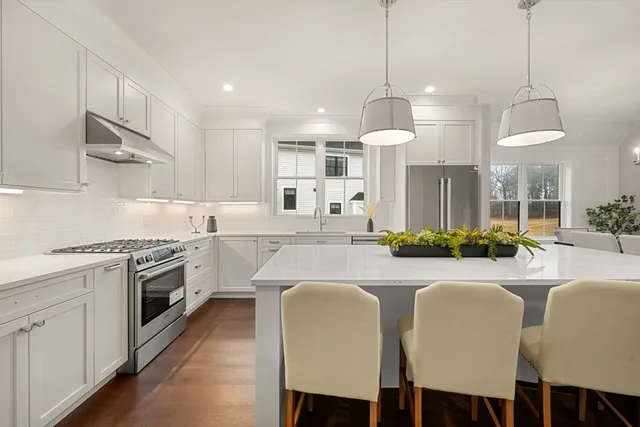 a large kitchen with white cabinets and stainless steel appliances