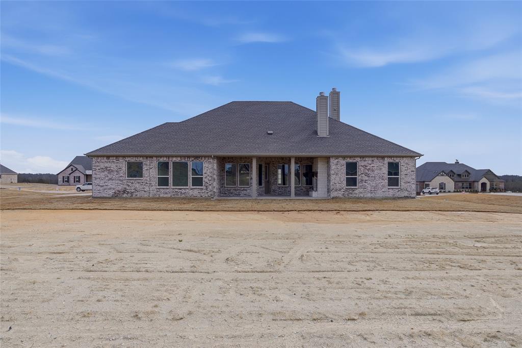 810 Vly Rdg Road Van Alstyne, TX 75495 - Photo 35 of 39 Back of house featuring a chimney, a patio, brick siding, and roof with shingles