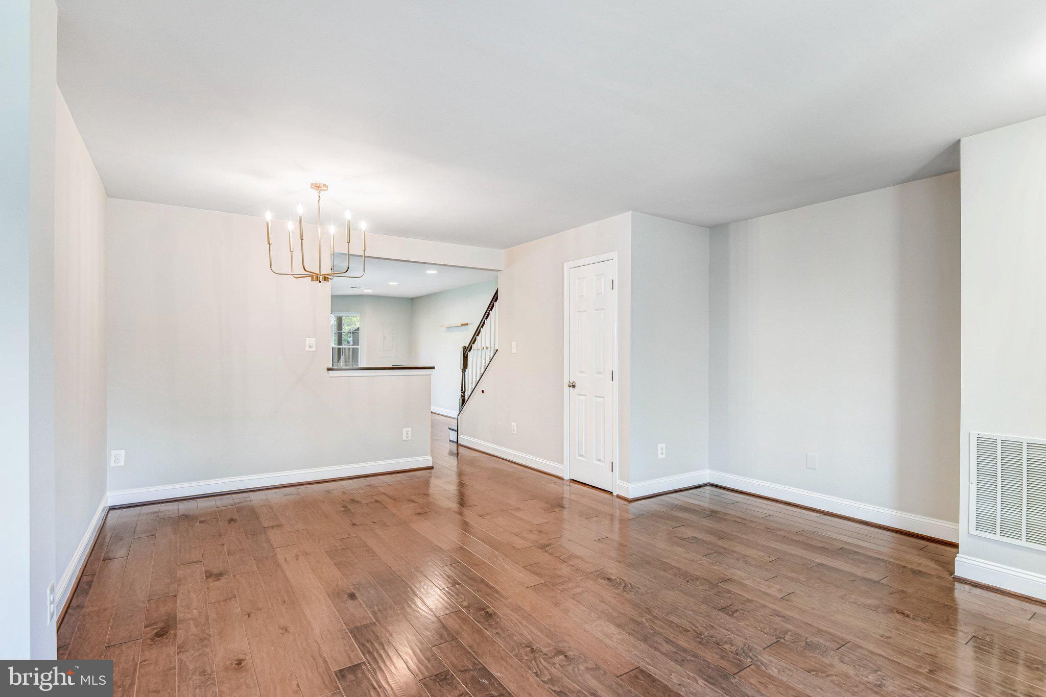 22142 Trailside Square Sterling, VA 20164 - Photo 7 of 32 an empty room with wooden floor mirror and windows