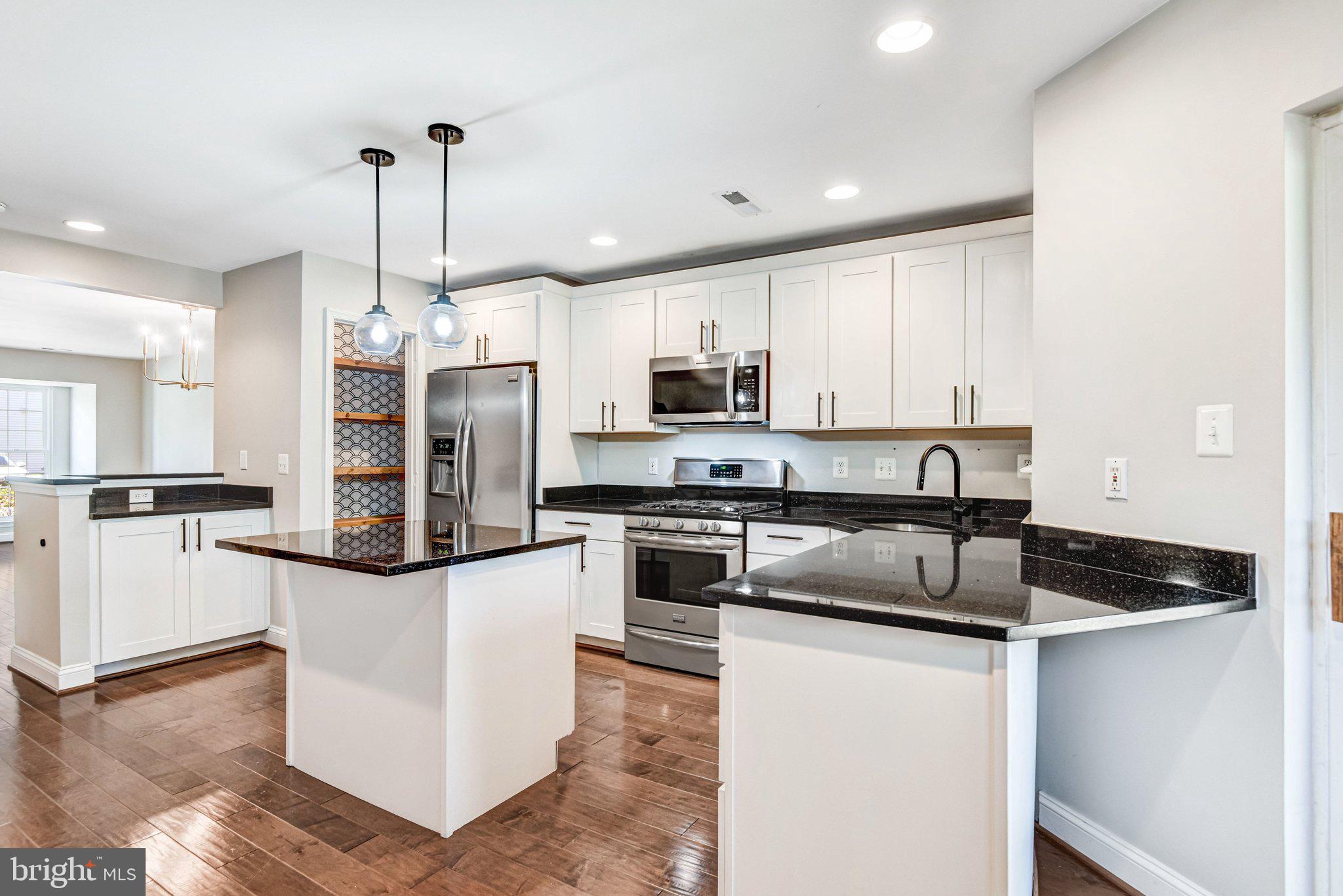 22142 Trailside Square Sterling, VA 20164 - Photo 10 of 32 a kitchen with stainless steel appliances granite countertop a sink and a refrigerator