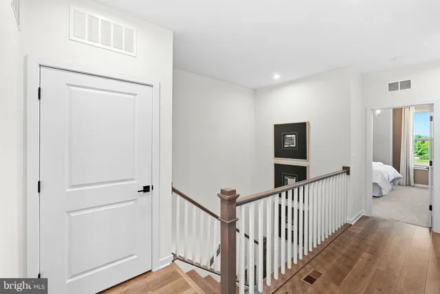 a view of a hallway with wooden floor and windows