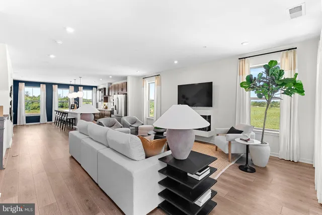 a living room with furniture a window and a potted plant